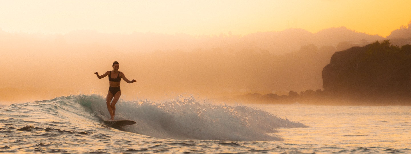 Person surfing at sunset in Lombok